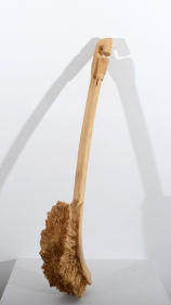 A toilet brush, scaled up and hand carved out of wood.